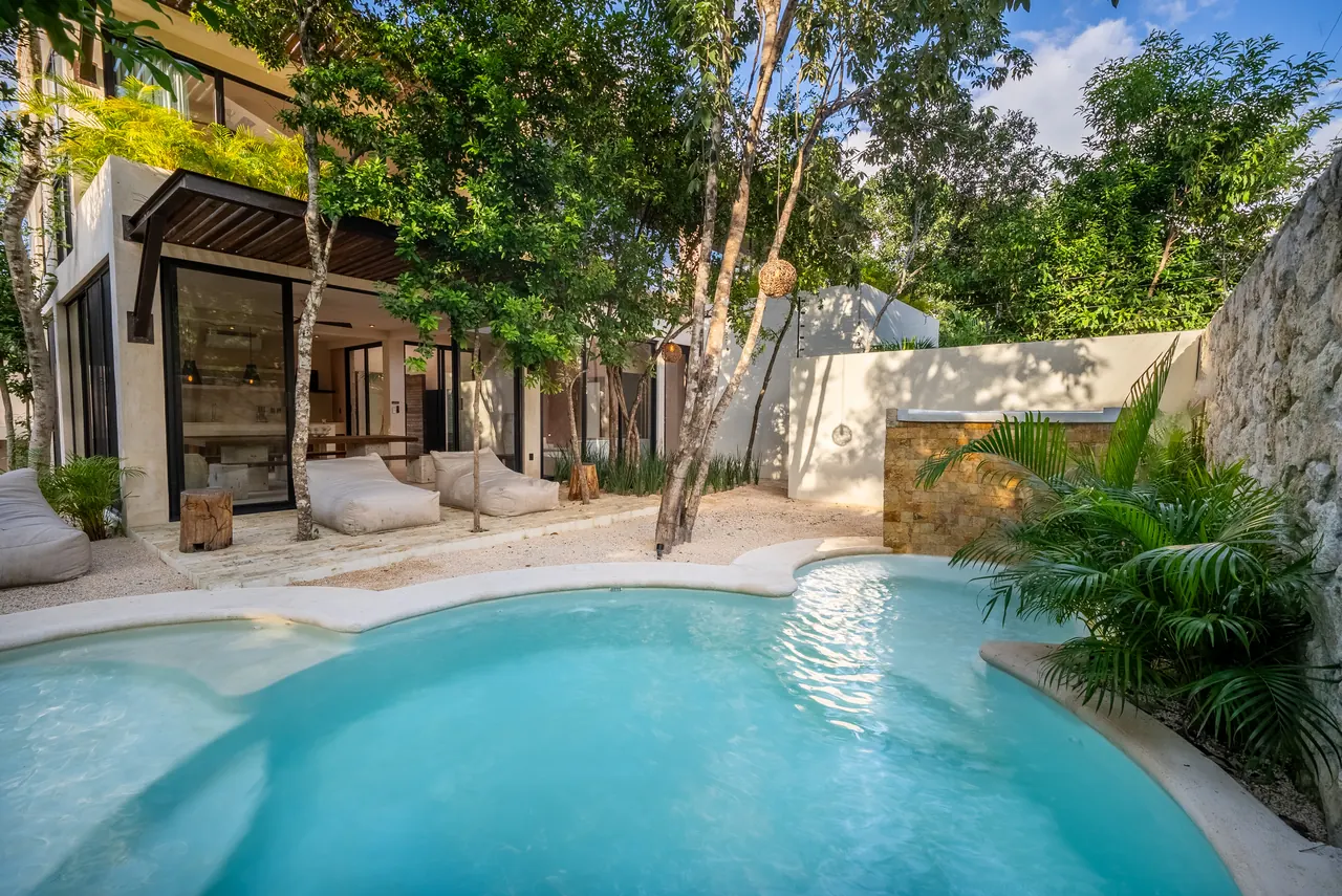 The main pool with its stone waterfall, framed by palms