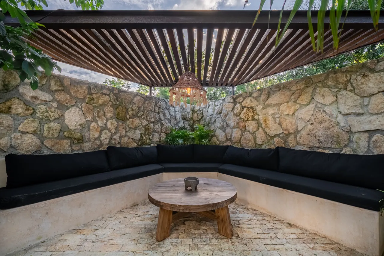 Sunken lounge with stone walls and pergola