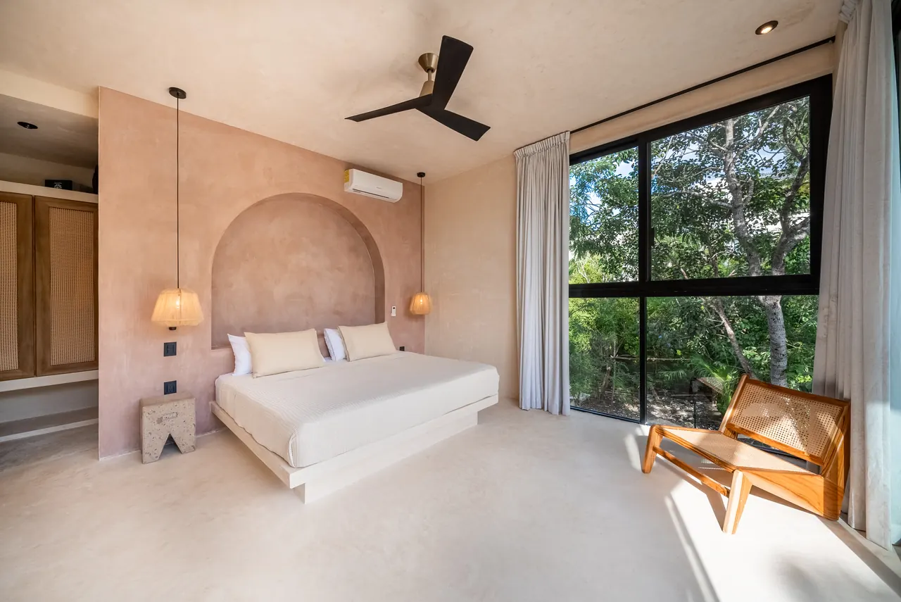 Master Bedroom 1: super king bed beneath an arched plaster headboard, beside floor-to-ceiling glass